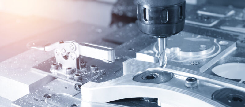 The CNC milling machine cutting the sample  part with the cutting tool in light blue scene and lighting effect