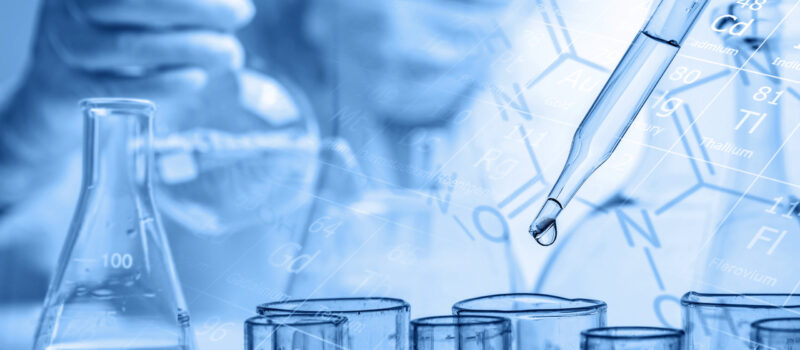 hand of scientist holding flask with lab glassware and test tube